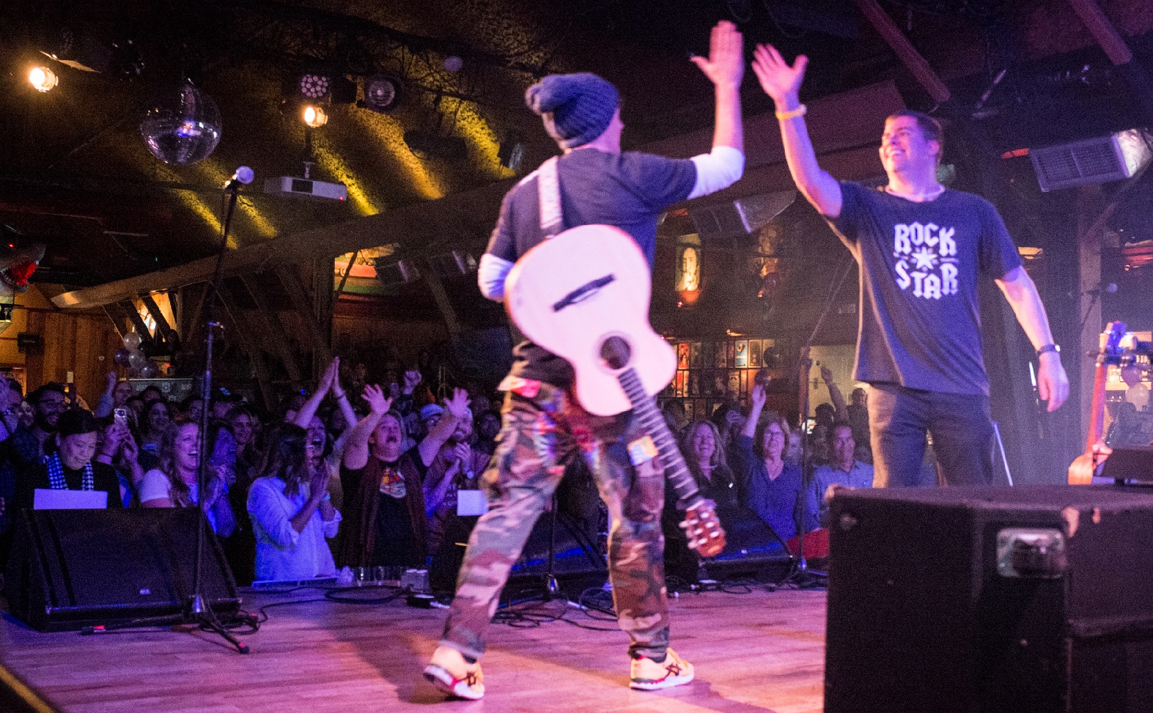 Men on stage high fiving